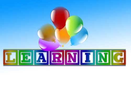 The word "learning" carried by balloons